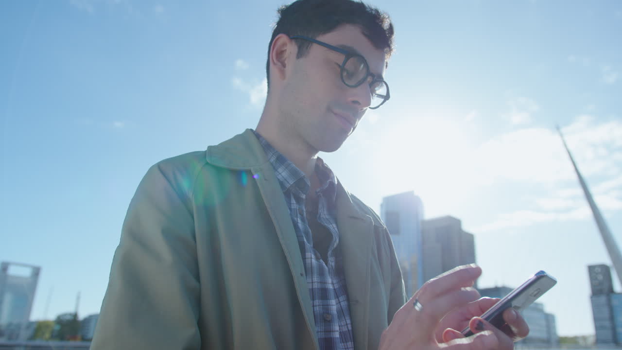 Young Businessman Texting on the Phone Outdoors in the City