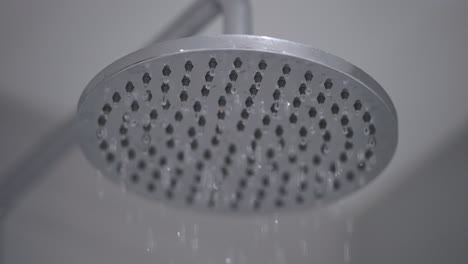 close up static shot of shower head dripping