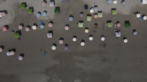 Toma-Aérea-De-Sombrillas-De-Playa-En-La-Arena