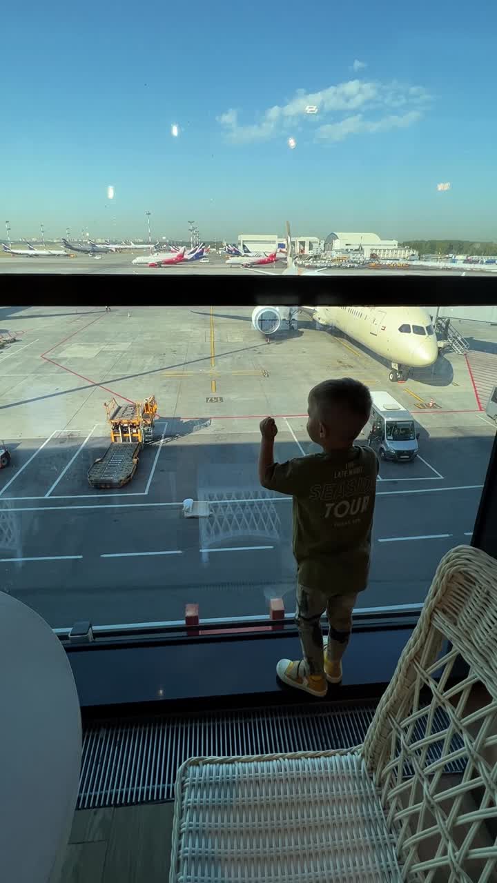 A young boy watching airplanes at an airport