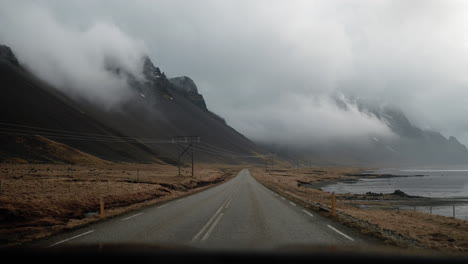 driving along route 1 in northern iceland, featuring expansive views of mountains, clouds, and coastal landscapes with grass