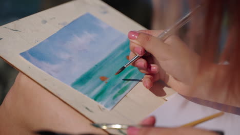 woman painting a watercolor seascape