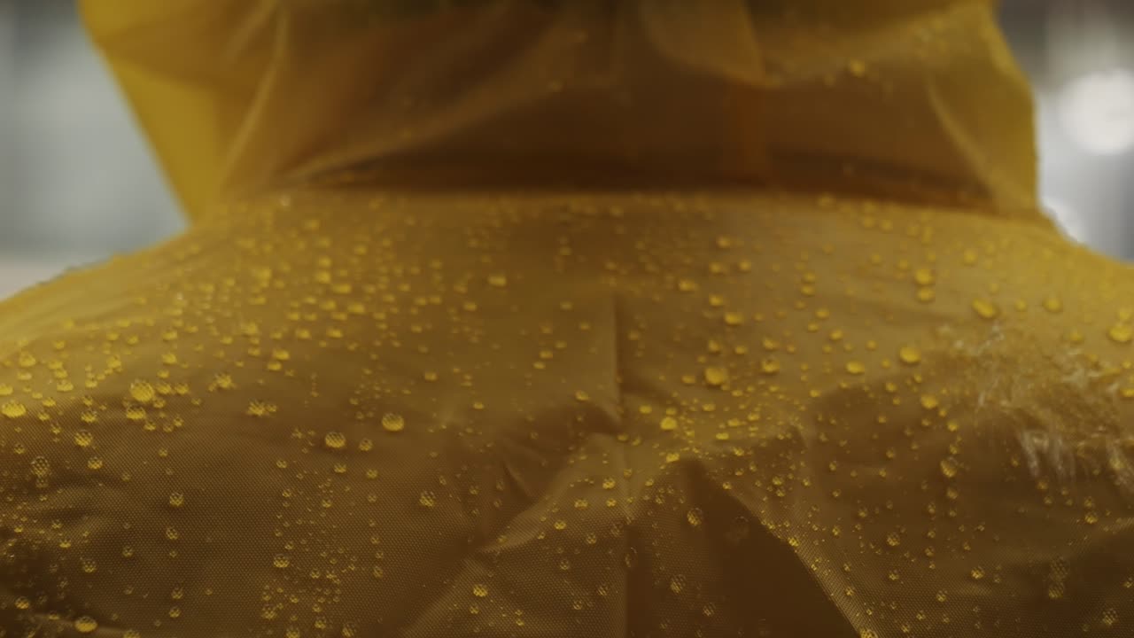 Business man tourist person with umbrella and raincoat on rainy european city street, lights reflecting, walking in Barcelona or Amsterdam during the rain