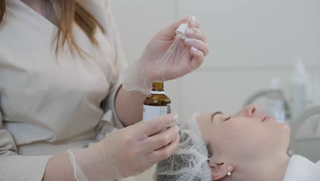 cosmetologist doing face treatment and applying face mask