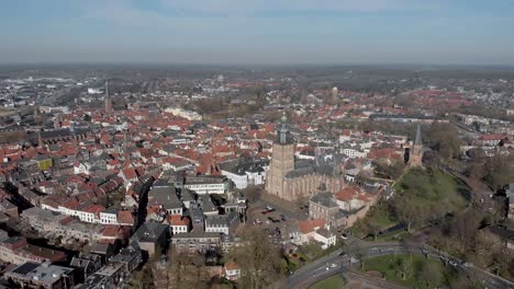 Malerische-Luftannäherung-Der-Mittelalterlichen-Hansestadt-Zutphen-In-Den-Niederlanden-Mit-Zentralem-Walburgiskerk-turm-Im-Vordergrund-Gegen-Einen-Blauen-Himmel