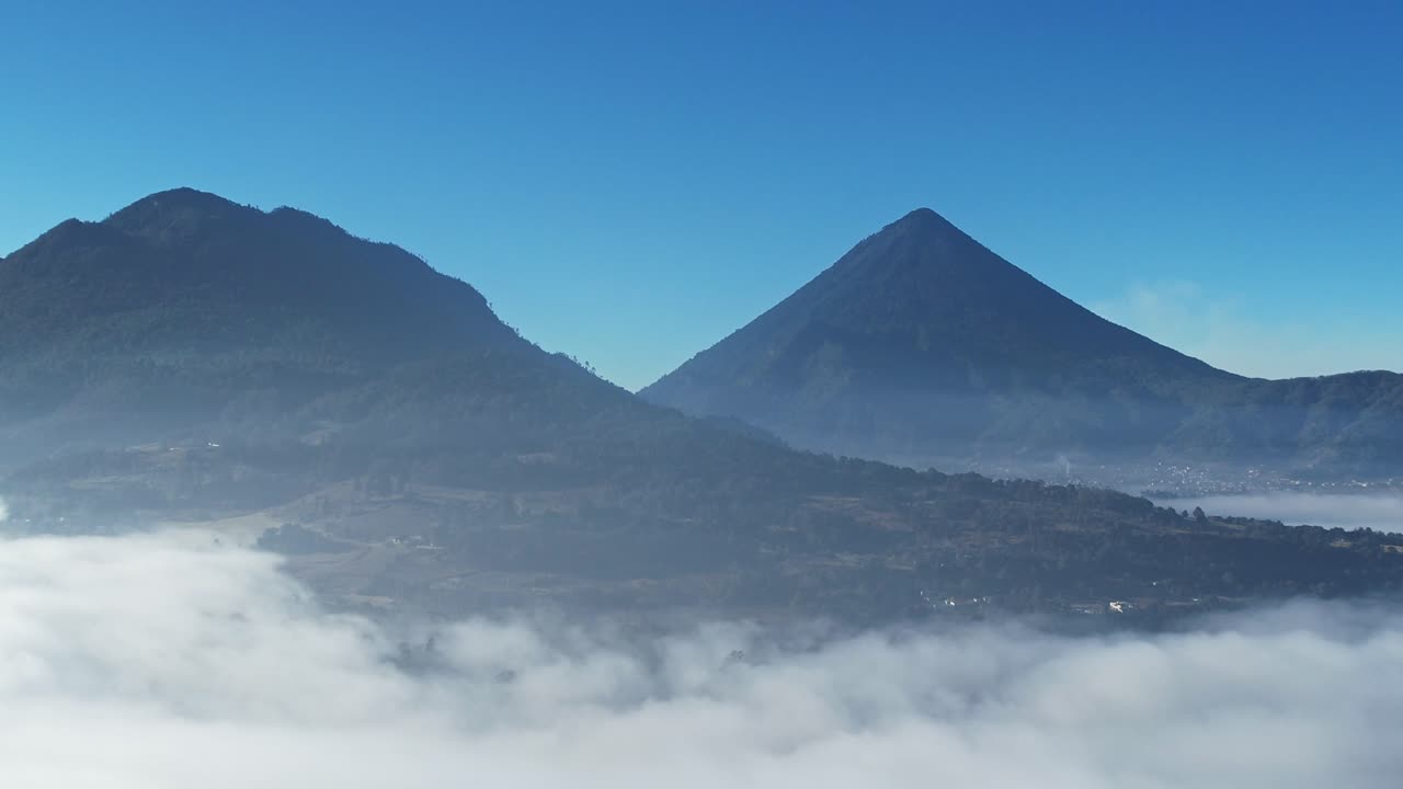 vista aérea de drones de dos volcanes por encima de la línea de nubes