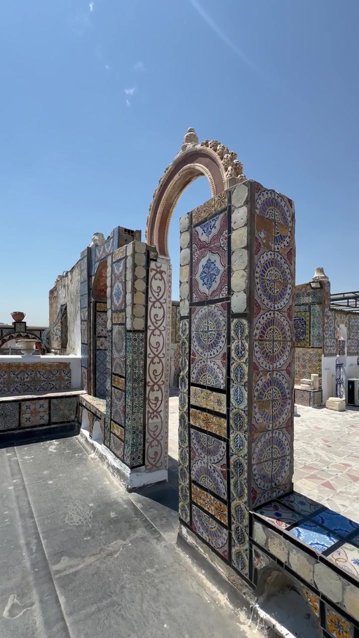 Vista panoramica a destra di piastrelle che coprono un arco sul tetto e panchine. Tunisi, Tunisia.