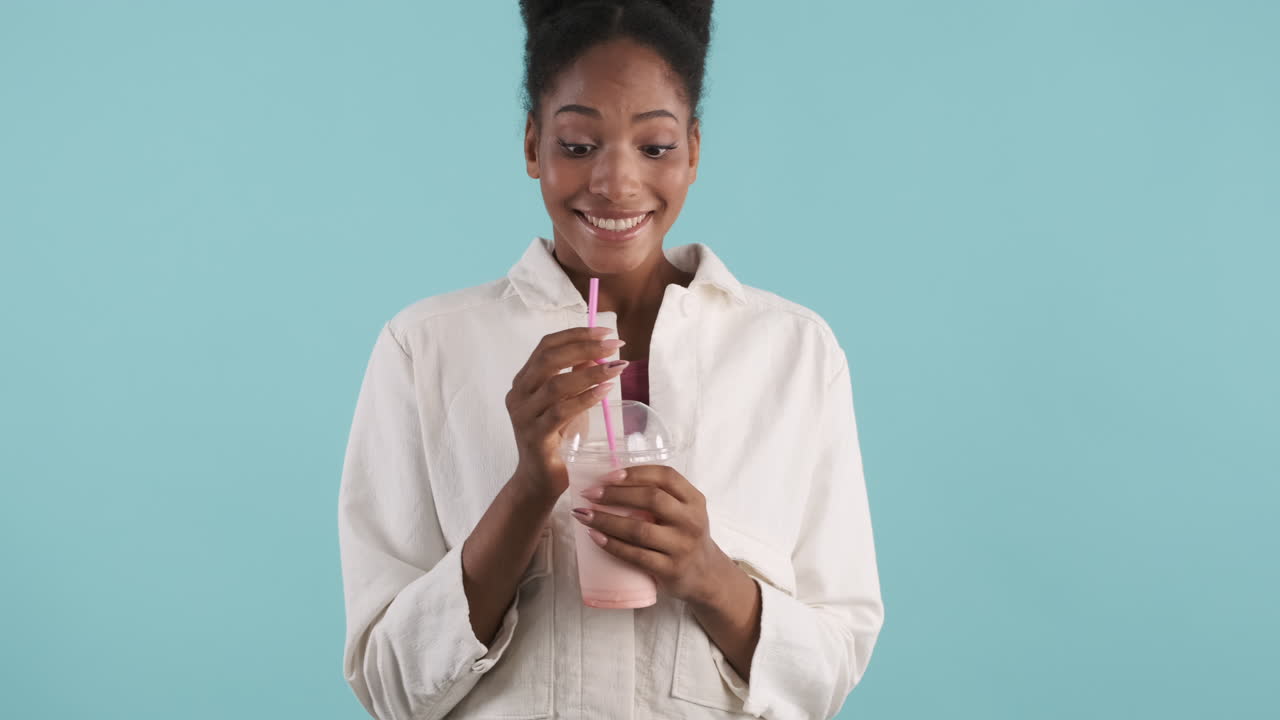 una mujer joven bebiendo un delicioso batido.