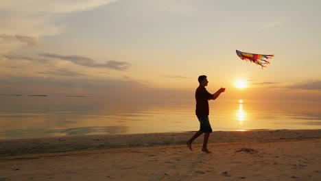 Teen-Spielt-Mit-Einem-Drachen-Bei-Sonnenuntergang-In-Der-Nähe-Des-Meeres-Steadicam-Zeitlupenaufnahme