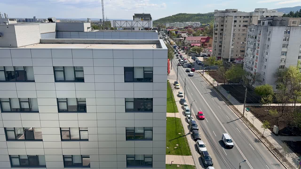Timelapse del traffico su Boulevard Poitiers a Iasi, Romania, con auto che si muovono attraverso un'area urbana residenziale e commerciale.