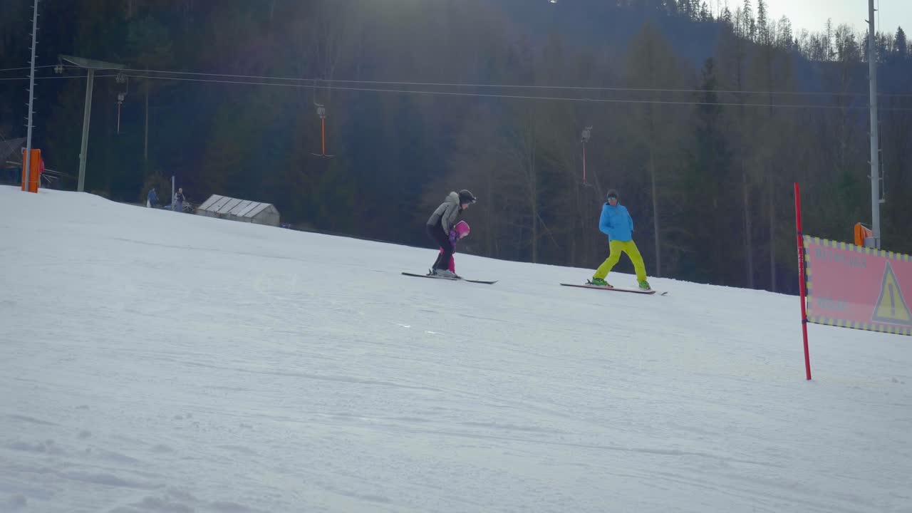 United family practising skiing on the piste for children with slight decline