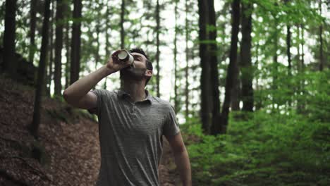 caucasian man running with coffee paper cup holding in hand and drinking it, cinematic front view