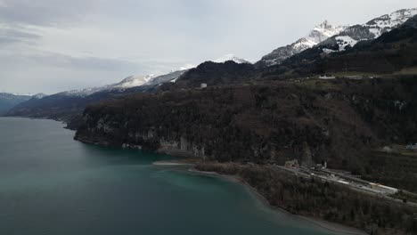 Un-Acantilado-Escarpado-Cae-A-La-Orilla-Del-Lago-Mientras-Un-Túnel-Corta-Debajo-De-La-Montaña-Para-Los-Automóviles