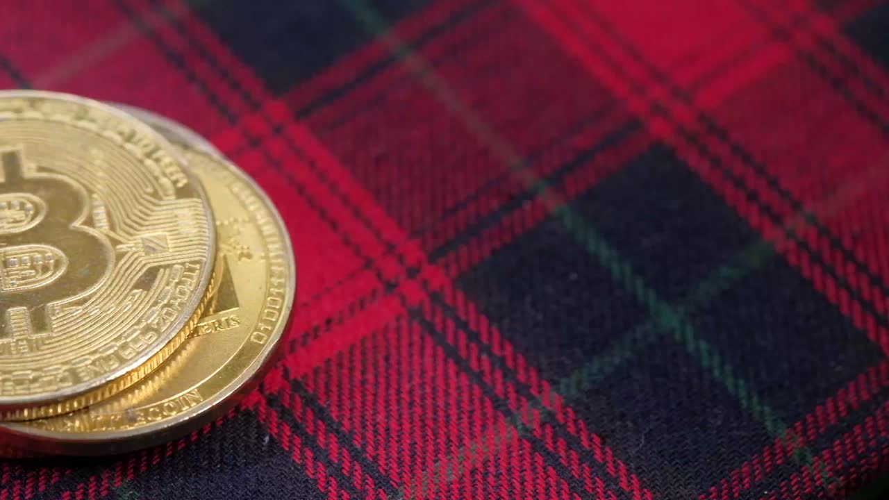 monedas de bitcoin en una tela a cuadros roja y negra