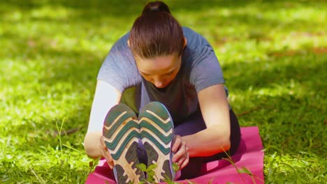 Close-up-slow-motion,-female-stretching-grassy-outdoors,-exercise-mat