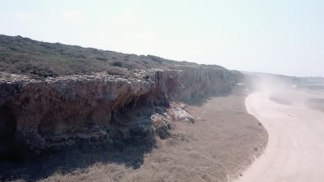 off-road along natural layered rock formation resembling a sheer cliff