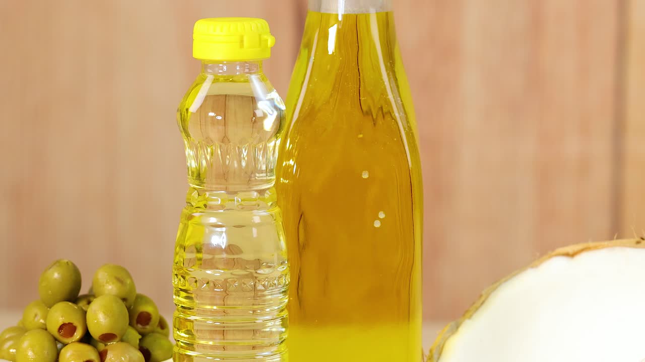 Various oils, nuts, and seeds arranged on a wooden surface with warm lighting, highlighting natural textures and colors