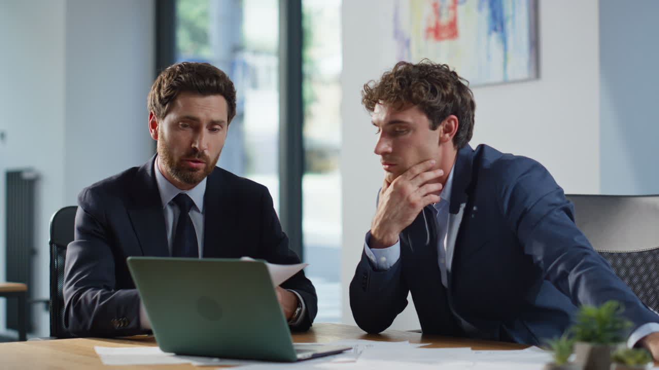 Smiling colleagues greeting laptop videocall in modern office space closeup