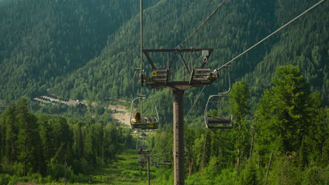 descent from viewing platform with green grass visible from cable car. tourists delight in contemplating amazing view of extensive forest and mountains