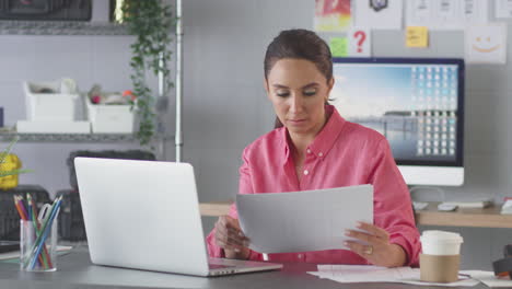 Businesswoman-In-Creative-Office-Working-At-Desk-On-Laptop