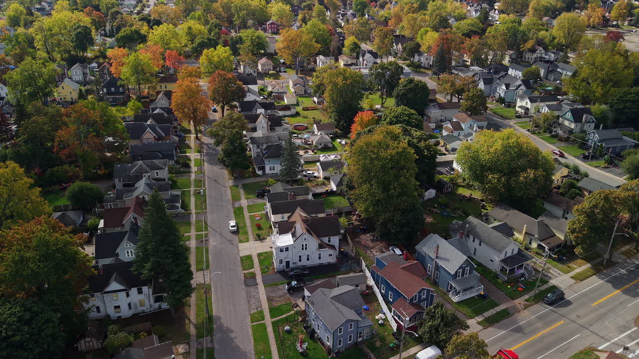 Vista aerea di un quartiere suburbano negli USA con case, strade residenziali e vivace fogliame autunnale in una giornata di sole.