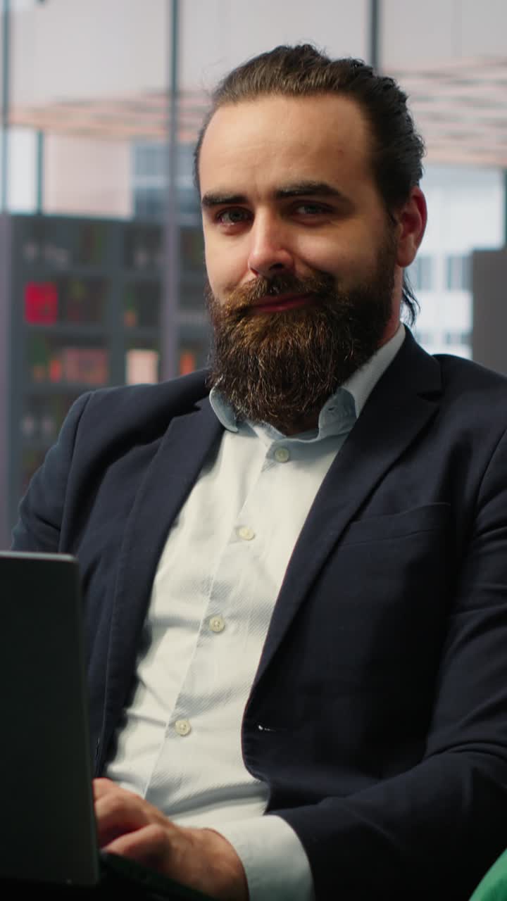 Video verticale: Leader uomo seduto in un ufficio moderno che dimostra autorità e produttività.