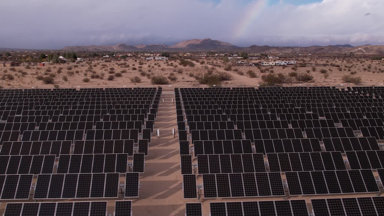 imágenes aéreas de drones del campo de paneles solares en el parque nacional del árbol de joshua en un día soleado con arco iris en el fondo, zoom horizontal rápido