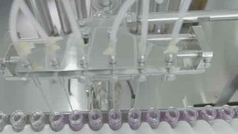 glass vials filled with medical liquid on a automated pharmaceutical production line in sterile environment