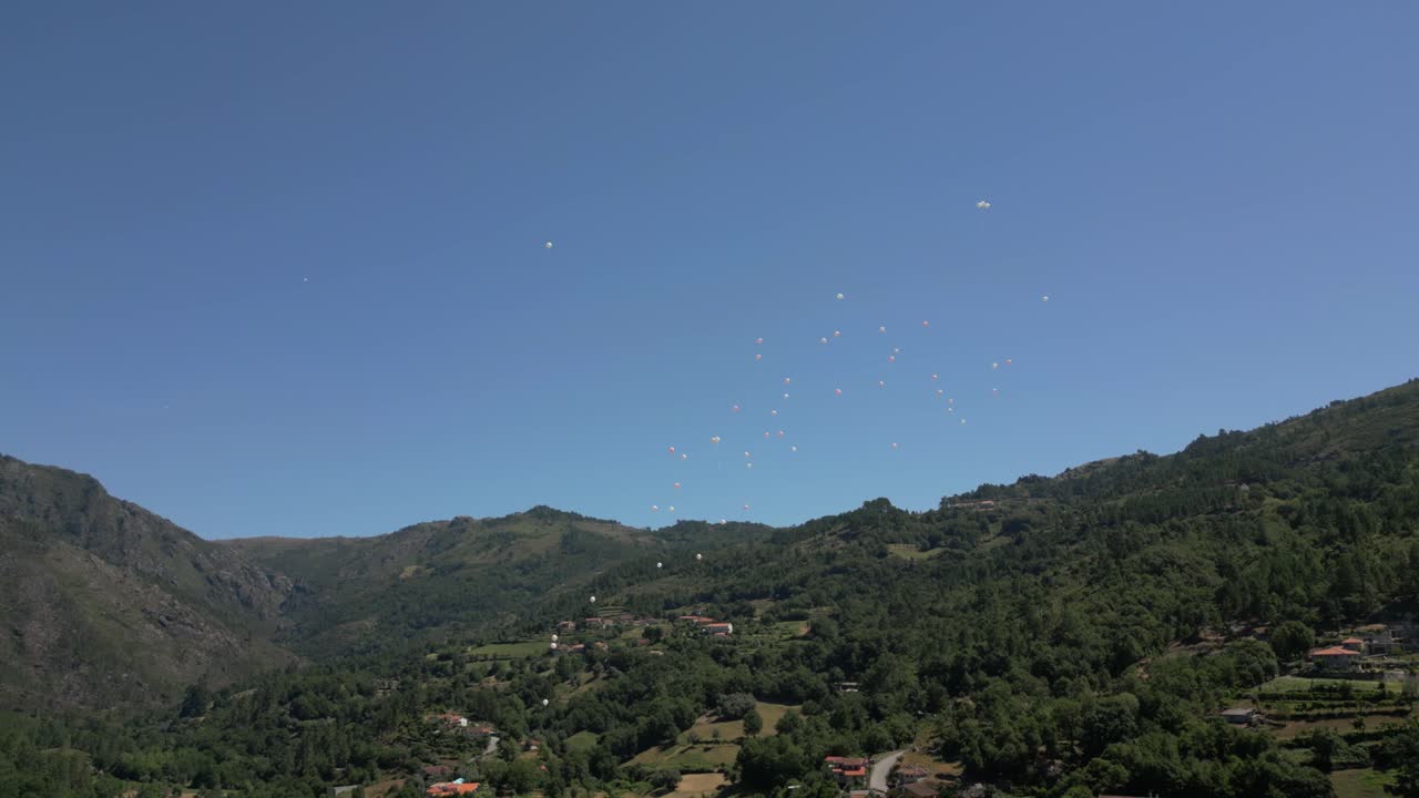 먼 산으로 둘러싸인 푸른 계곡 위에 떠다니는 풍선, 은 하늘