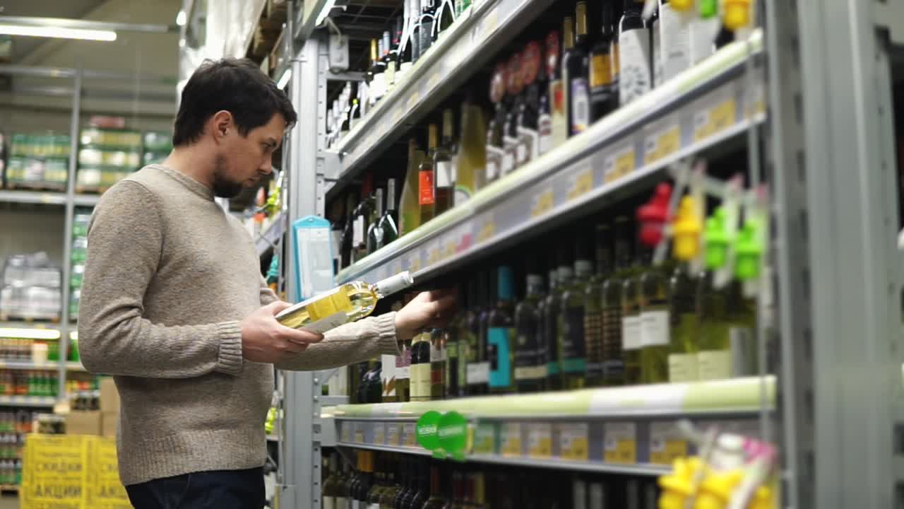 hombre comprando vino en un supermercado