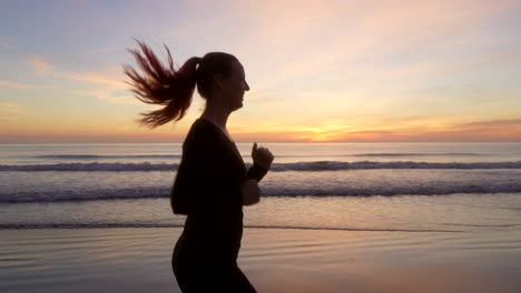 happy woman running along the seashore with beautiful sunrise light