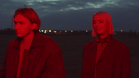 young couple walking in red light outdoors