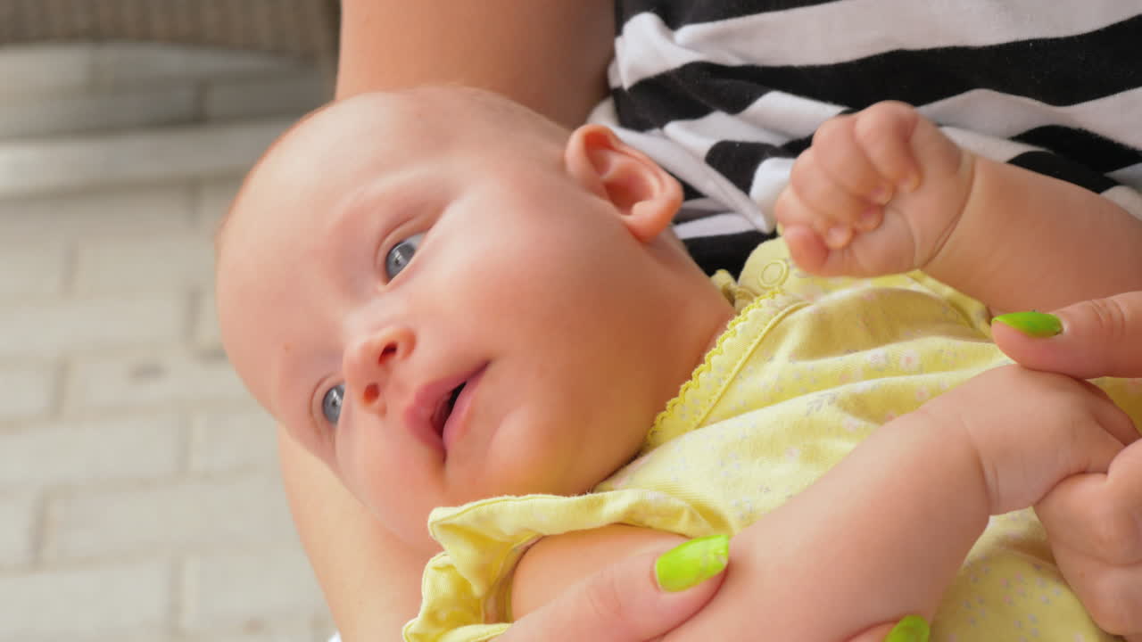 엄마의 손에 누워있는 귀여운 아기 소녀