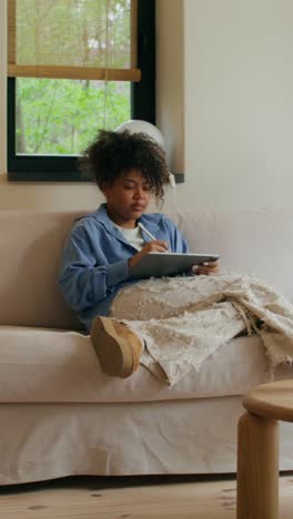 woman drawing on a tablet at home