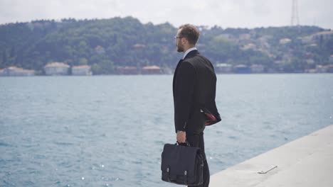 Hombre-De-Negocios-Pensativo-Mirando-El-Mar.-Vista-De-La-Ciudad.