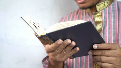 muslim man hand holding holy book quran with copy space