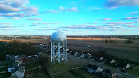 flying toward and past a water tower in a suburban neighborhood