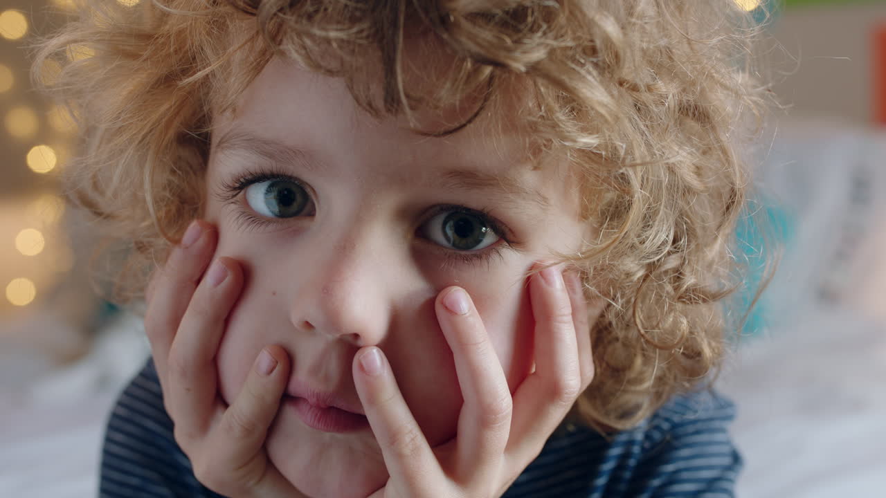 retrato de un niño tímido con el cabello rizado mirando a un niño infeliz en casa