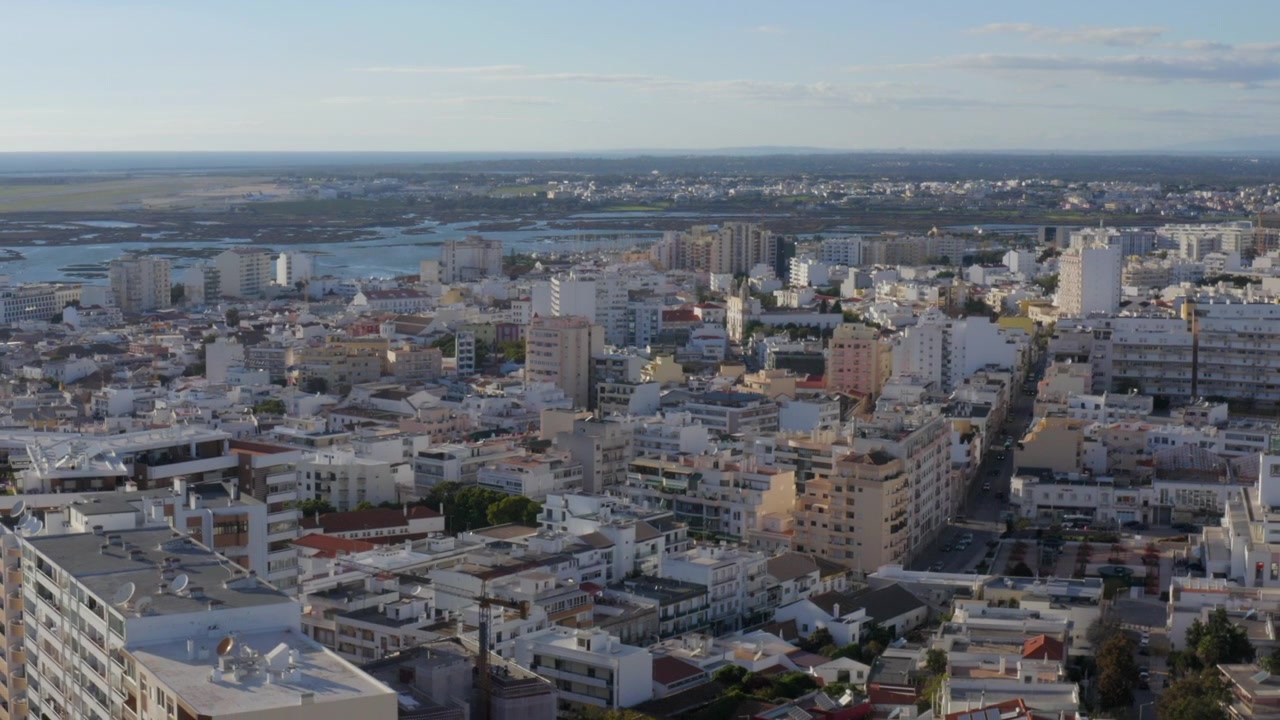 Tomada aérea da paisagem urbana de Faro, horizonte residencial junto à Ria Formosa, Algarve
