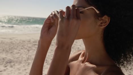 mujer con gafas de sol en la playa 4k