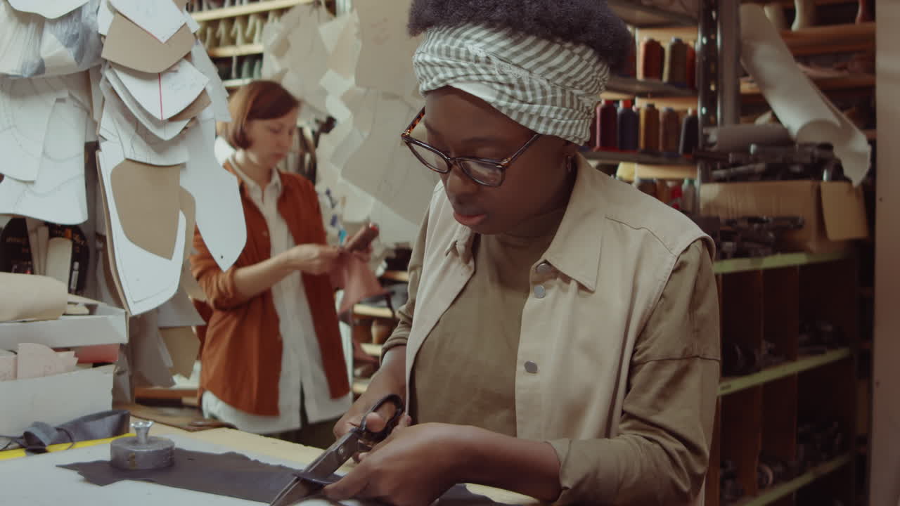 African American Female Shoemaker Cutting Leather in Workshop