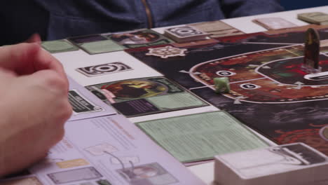 hand gestures and playing desk board game named unpredictable, high angle closeup view