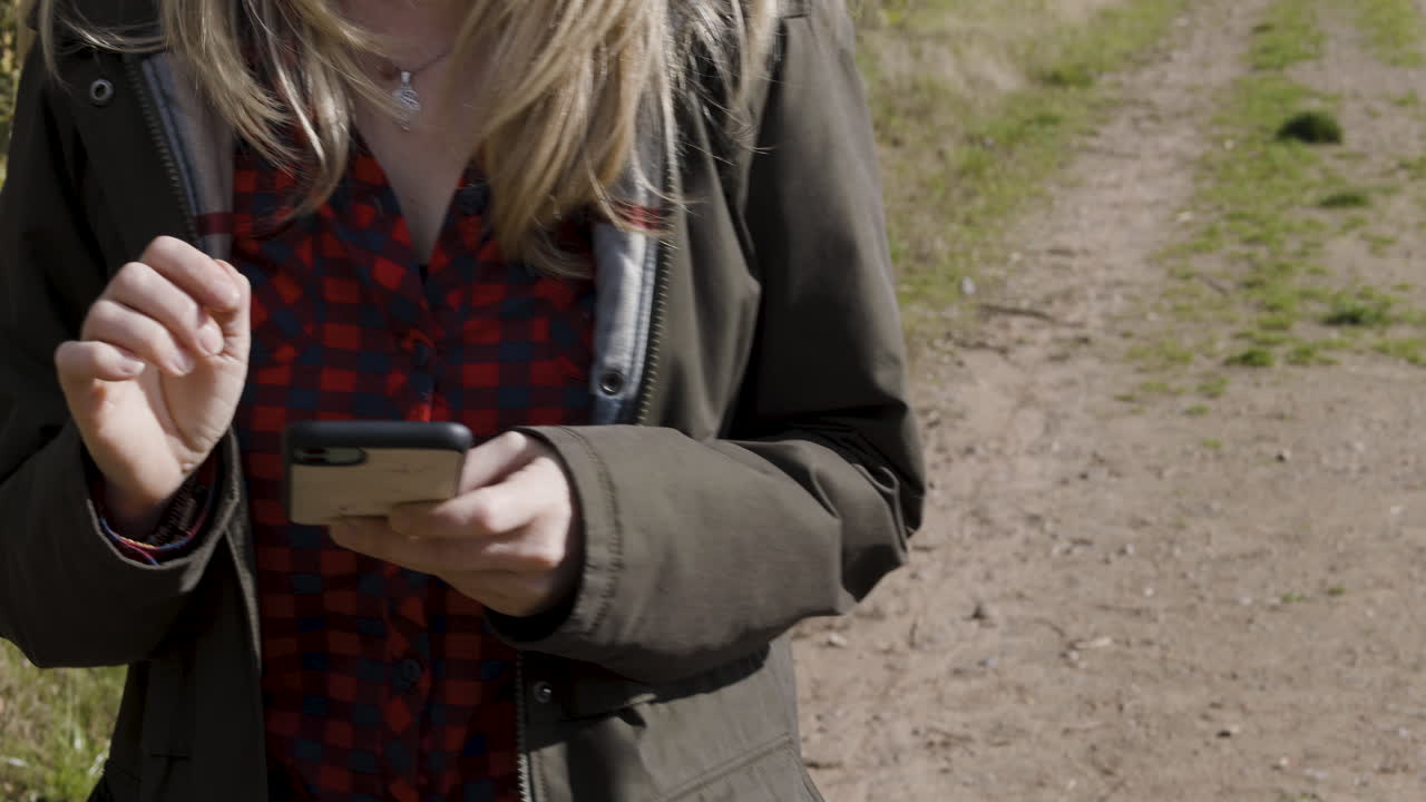 Woman using phone on path