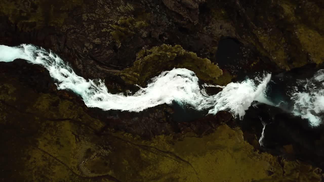 vista superior de drones aéreos sobre el agua que fluye por la cascada de ófærufoss, en las tierras altas de islandia