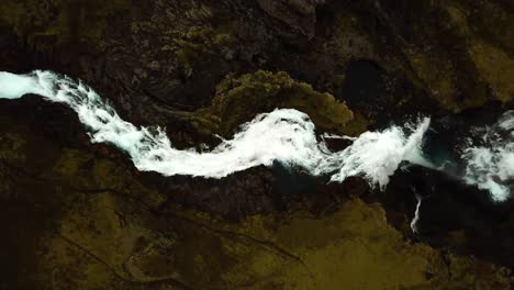 aerial drone top view over water flowing down ófærufoss waterfall, in iceland highlands