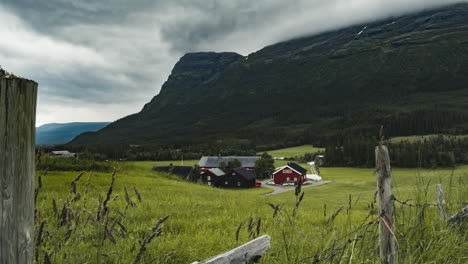 beautiful farmhouse on the lush field by the mountain in hemsedal, norway - zoom-in shot - timelapse