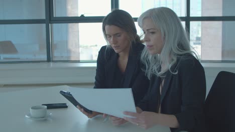 colegas mujeres discutiendo informes