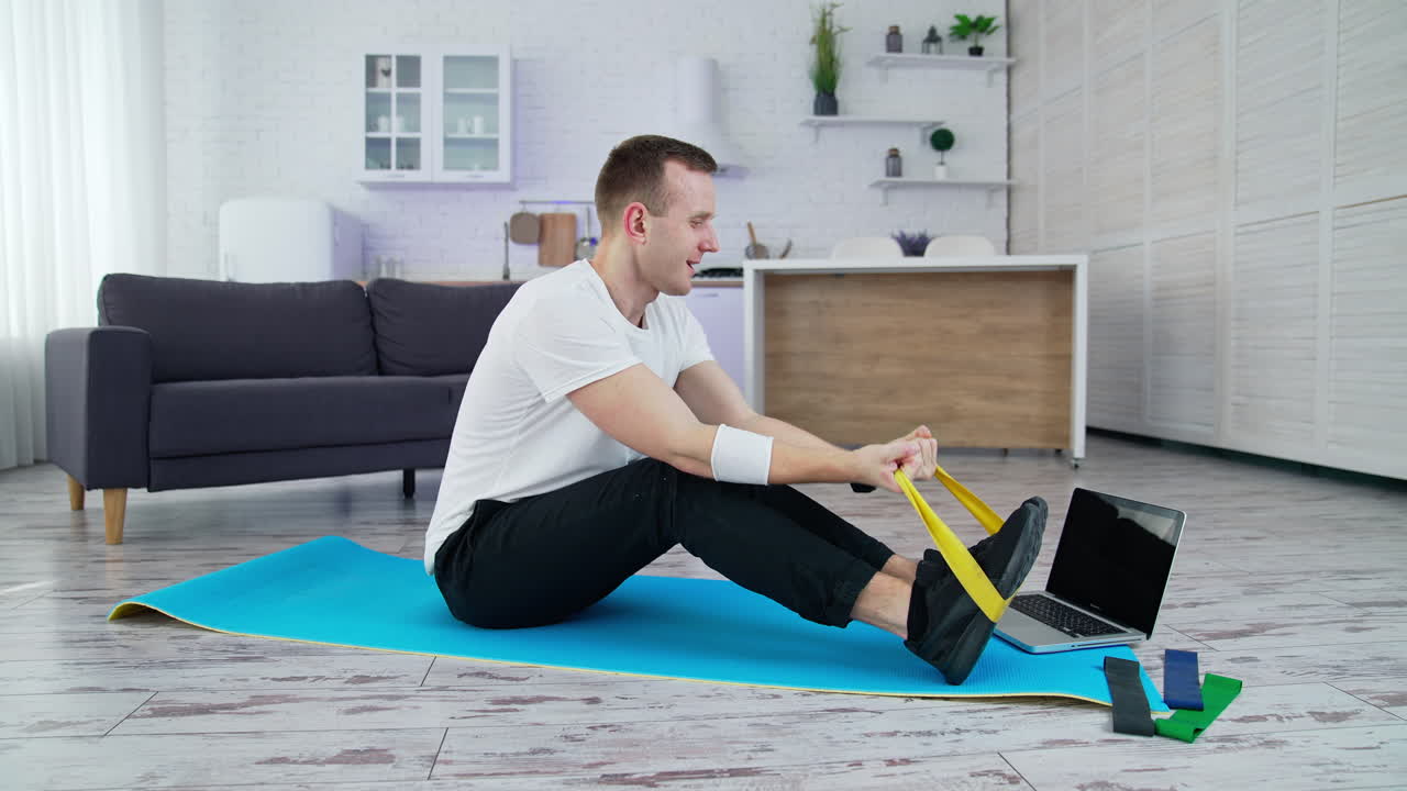 healthy workout at home. Man sitting on the floor at home and doing exercises for his hands