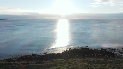 vesturbær coastal area with bright sunlight reflecting on ocean surface, aerial