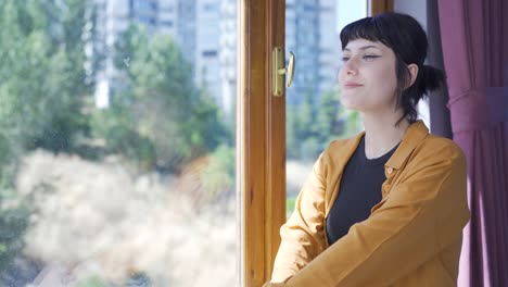 A-lively-and-energetic-young-woman.-Laughing-out-the-window-with-happy-expression.